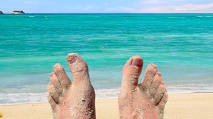 sandige Zehen einer Person am Strand